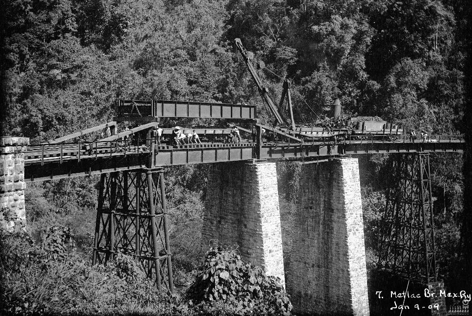 El puente de Metlac durante su reforma el 9 de enero de 1909. Se aprecian todavía dos de los pilares de hierro fundido originales y dos pilares ya revestidos de cantería. La imagen muestra el momento en que se cambian las vigas laterales. Fondo Ferrocarril Mexicano. CEDIF, CNPPCF, Secretaría de Cultura.
